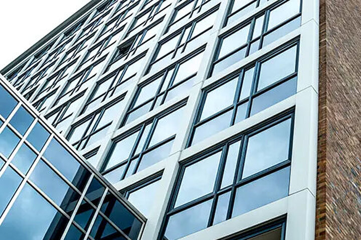 DSR_Asset_Leistungen Fassade eines modernen Bürogebäudes mit Glasfront, Blick von unten